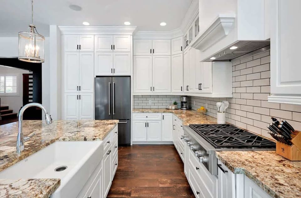 The kitchen offers a bright, spacious layout with ample cabinetry, stainless steel appliances, and a center island with seating for 4.