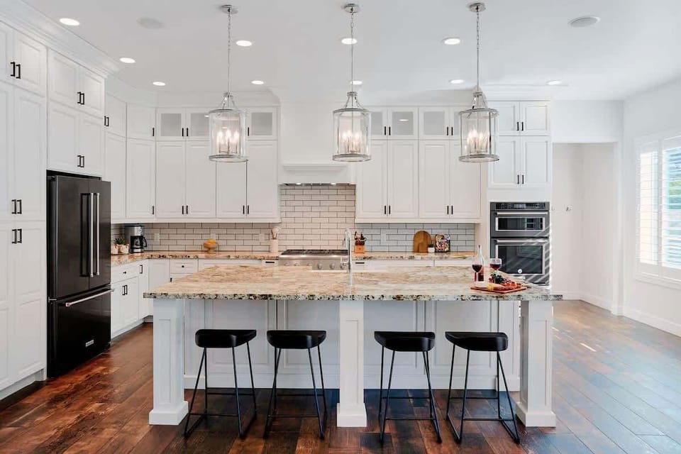 The kitchen offers a bright, spacious layout with ample cabinetry, stainless steel appliances, and a center island with seating for 4.