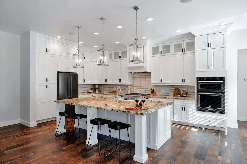 The kitchen offers a bright, spacious layout with ample cabinetry, stainless steel appliances, and a center island with seating for 4.