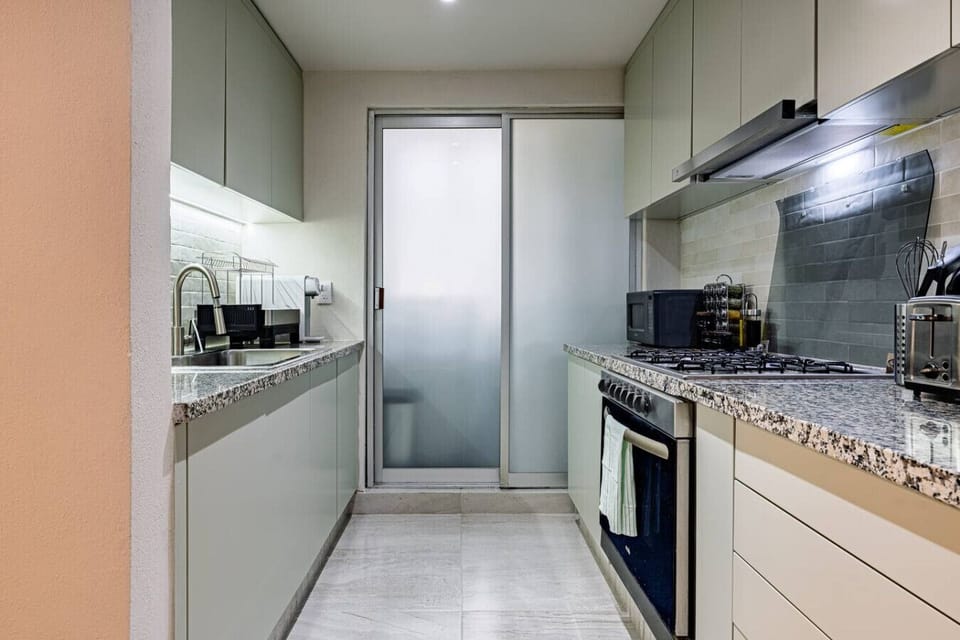 Contemporary kitchen with stainless steel appliances and granite countertops.