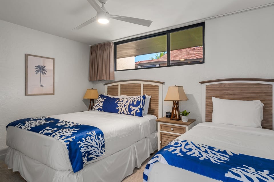 Unwind in a welcoming guest room offering two plush beds and a peaceful atmosphere.