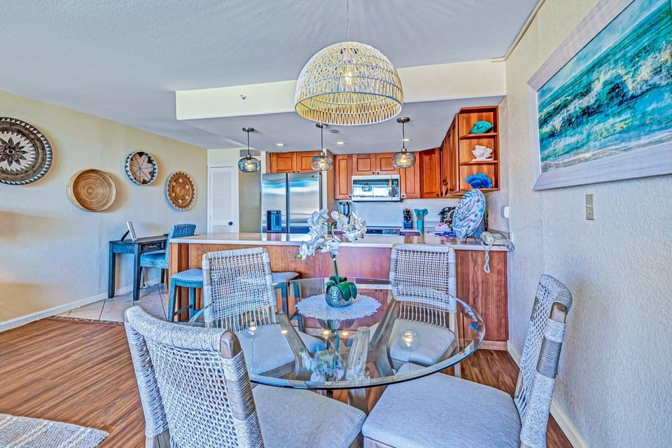 Gather in a chic dining nook adjacent to a modern kitchen, featuring rattan accents, a statement pendant light, and a harmonious mix of textures for a relaxed yet refined atmosphere.