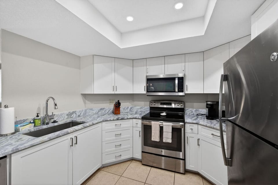 Modern kitchen w/ sleek counters, stainless appliances, and plenty of space to prep meals.