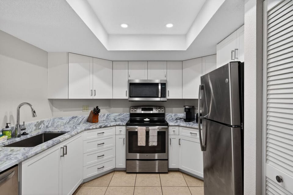 Fully equipped kitchen w/ sleek cabinetry and stainless appliances, designed for easy home cooking.