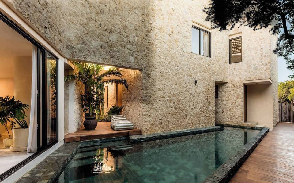 Private courtyard pool framed by textured stone walls.