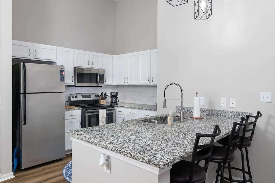 Open-concept, fully-equipped kitchen with eat-in bar.