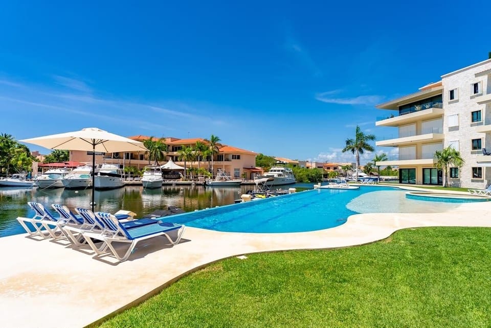  Disfruta de una piscina infinita con vista directa a la marina. Relájate bajo el sol mientras contemplas los yates y el cielo azul caribeño. Acceso inmediato desde tu terraza.