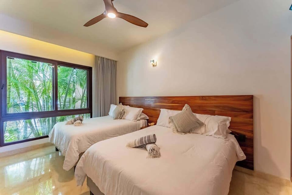 ‍‍‍ Ideal para niños, amigos o familias: dos camas individuales, ventilador de techo y vista al jardín en una habitación fresca y versátil.