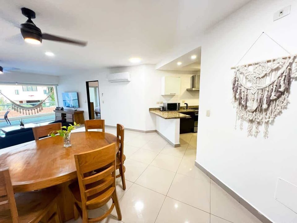 Cocina con barra de granito, refrigerador, microondas, cafetera y más. Espacio abierto conectado al comedor, pensado para cocinar y compartir.
cocina equipada, barra de granito, comedor, cocina abierta