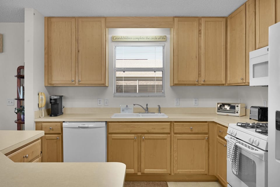 Your fully equipped kitchen with warm wood cabinets and modern appliances makes cooking feel like home.