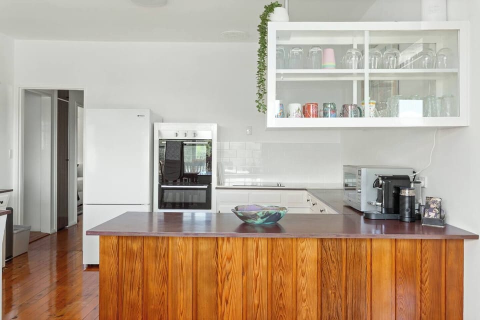 The kitchen delivers practical cooking with ample bench space, an oven, stovetop, fridge, dishwasher and microwave for effortless meal preparation.