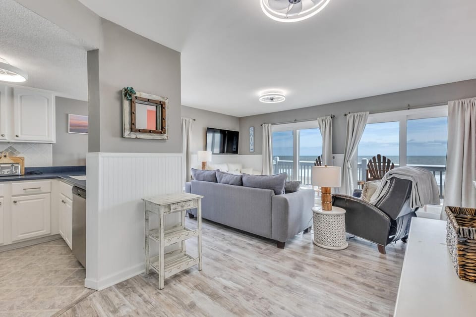 Relax in your bright coastal living room where ocean views through large windows create the perfect backdrop for your beach getaway.