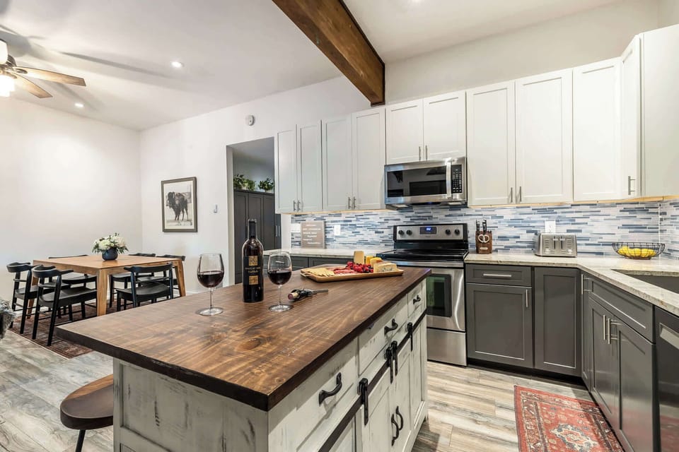 Open kitchen with island seating and dining table (charcuterie board and wine, not included)