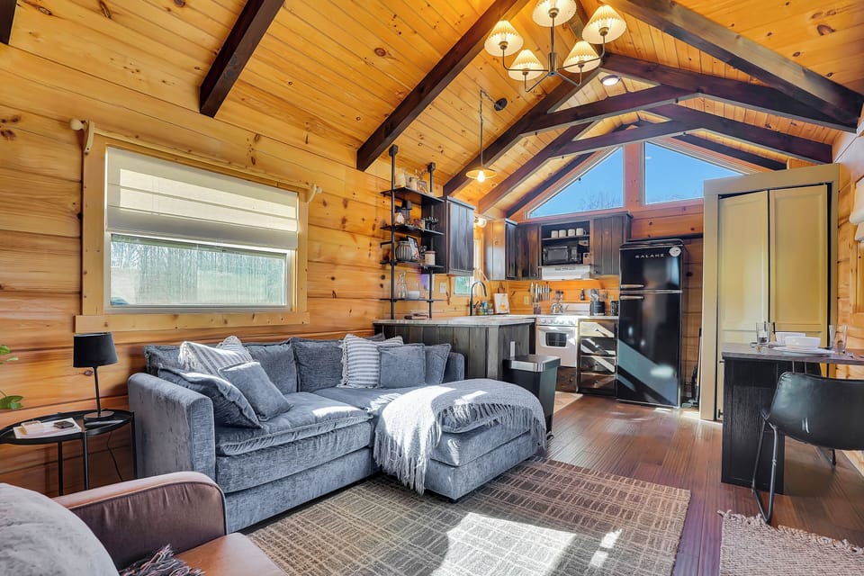The interior space of this cabin is beautifully laid out with a living area, small dining space, and custom kitchen area.