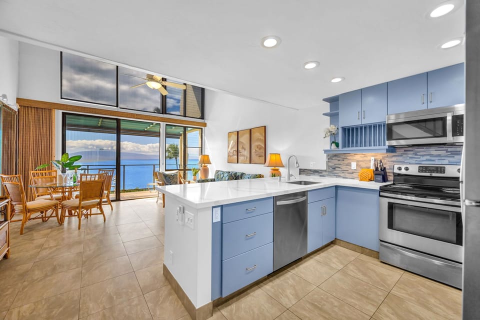The modern, open-concept kitchen features elegant countertops and blue accents, ensuring you never miss the view while preparing a meal
