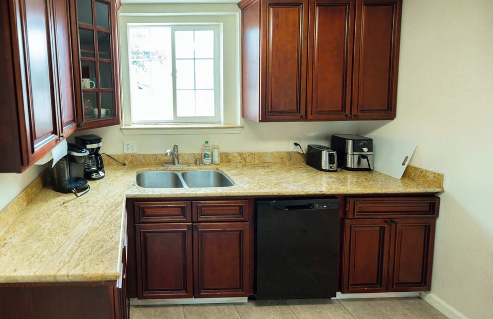 Enjoy the comfort of this well-appointed kitchen, where classic wood cabinets and modern appliances create a welcoming space to prepare your favorite dishes