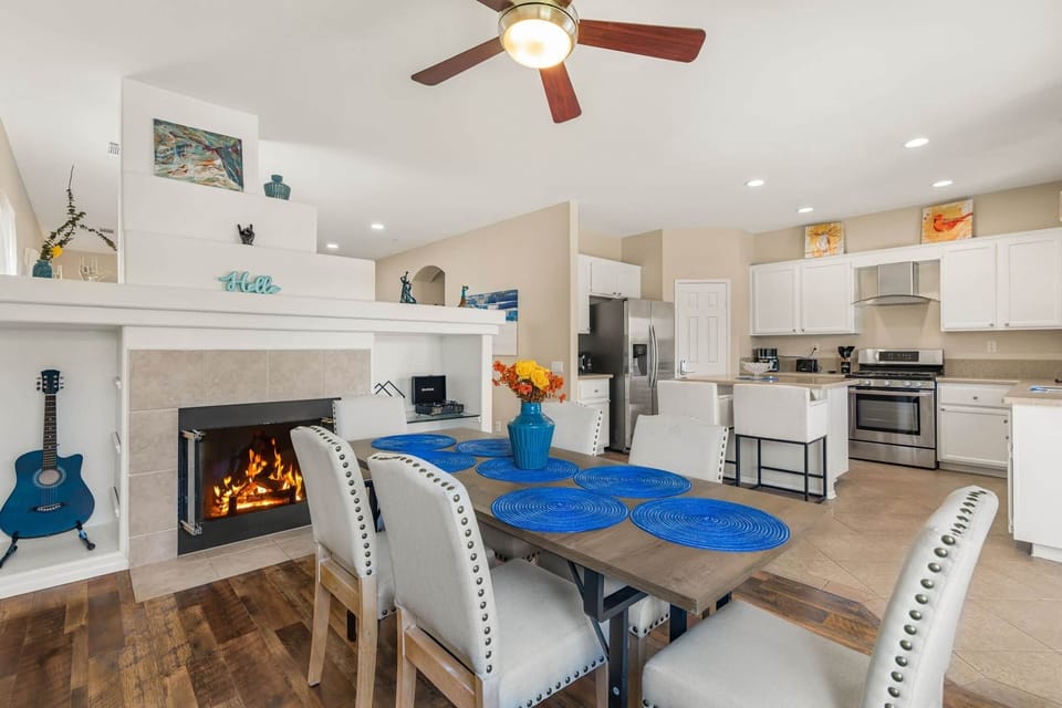 Elegant, cozy dining area with fireplace warmth and a ceiling fan above for comfort.