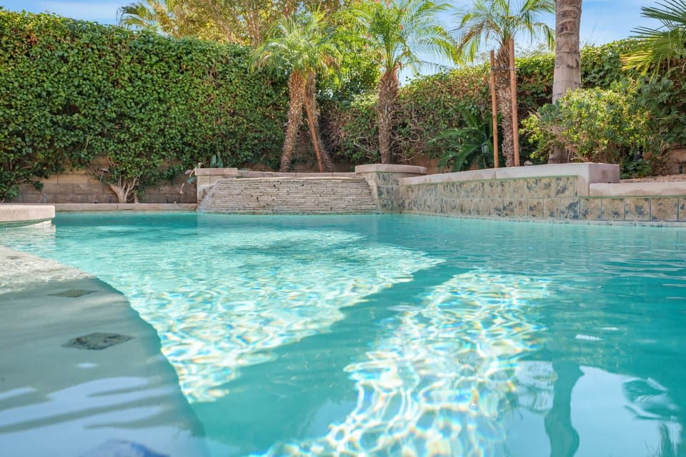 The water is a bright, inviting turquoise blue, with strong sun reflections indicating a sunny envir