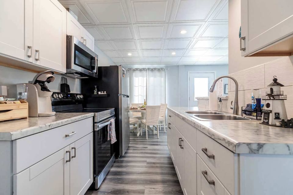 Bright, fully equipped kitchen with sleek stainless steel appliances, opening into the dining area. The open layout is perfect for cooking, serving, and gathering together, making meals feel easy and inviting.