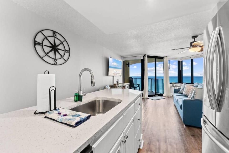 Prepare meals with a view—kitchen opens to the living room overlooking the emerald Gulf waters.