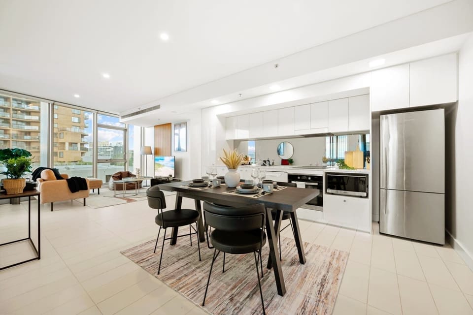 Expansive open-plan living and dining area with floor-to-ceiling windows, modern furnishings, and a seamless flow throughout.