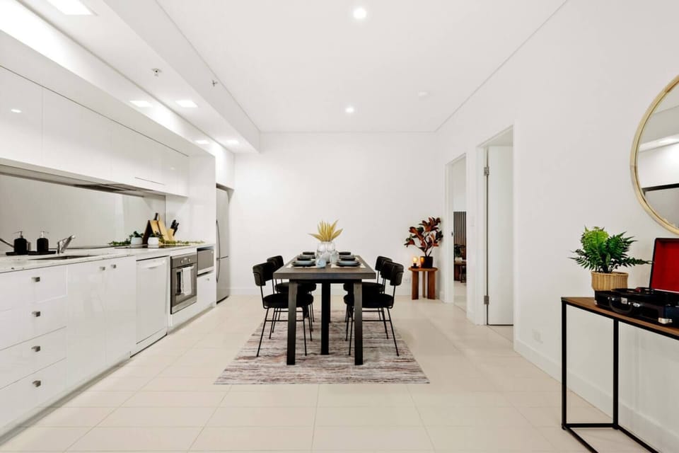 A clean and stylish dining setup positioned perfectly between the kitchen and living spaces, ideal for hosting or relaxing meals.