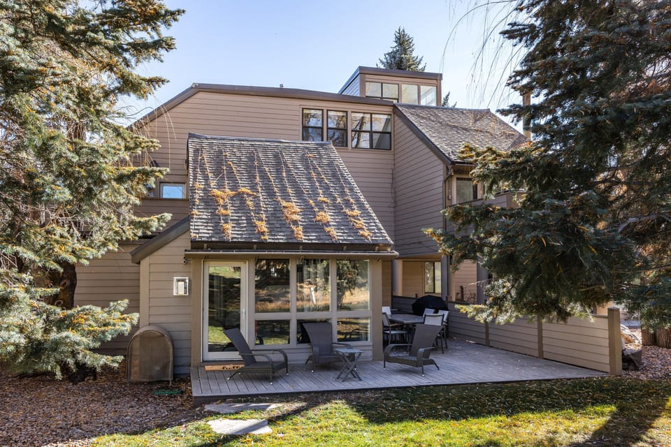 Quiet, tree-lined exterior with an inviting patio area for morning coffee or evening downtime