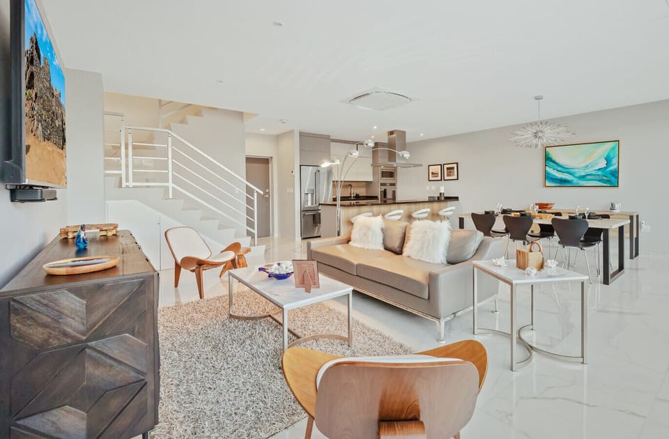 Modern open-plan space with a full kitchen, dining area, and cozy lounge — perfect for gathering, sharing meals, and relaxing together during your stay.