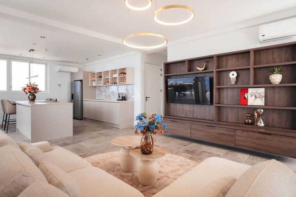 Unwind in the spacious, open-plan living area. Floor-to-ceiling glass doors open to the balcony, filling the room with natural light and offering stunning ocean views.