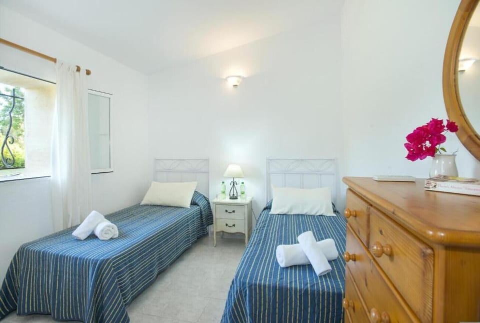 Bright twin bedroom with simple décor and garden views in a holiday villa.