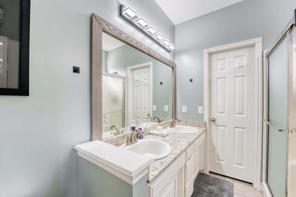 Second full bath with double sinks, walk‑in glass shower, and hotel‑quality finishes.