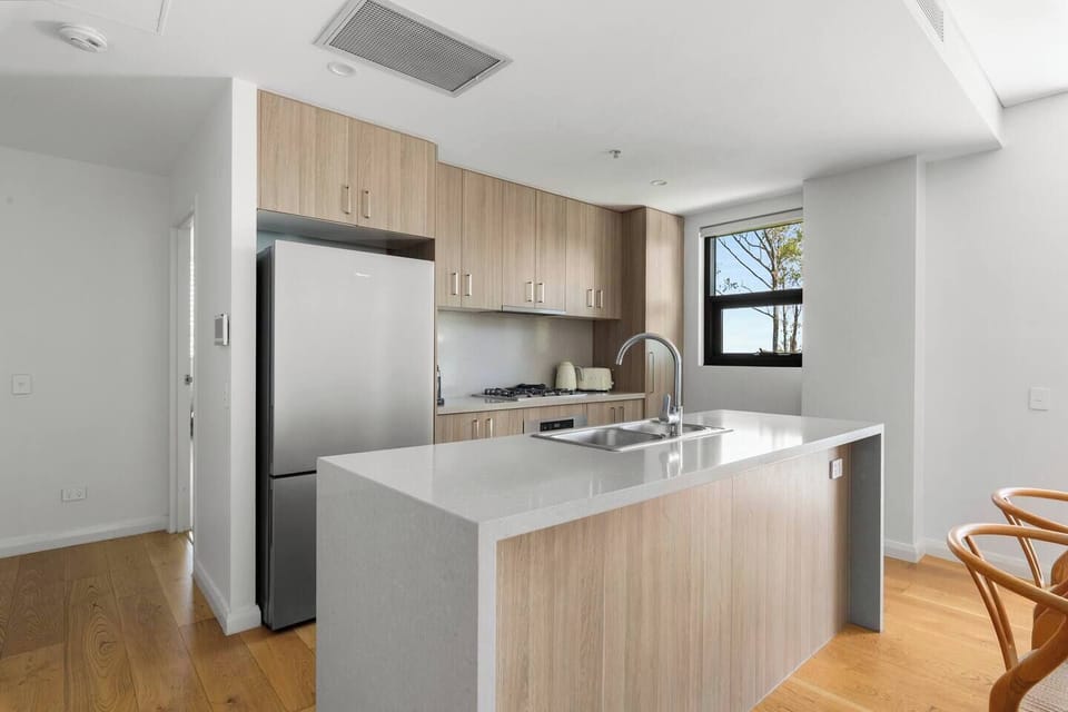 Prepare meals with ease in the modern kitchen equipped with an oven, gas cooktop, microwave, dishwasher, Nespresso machine and full-sized fridge, all arranged to support home cooking.