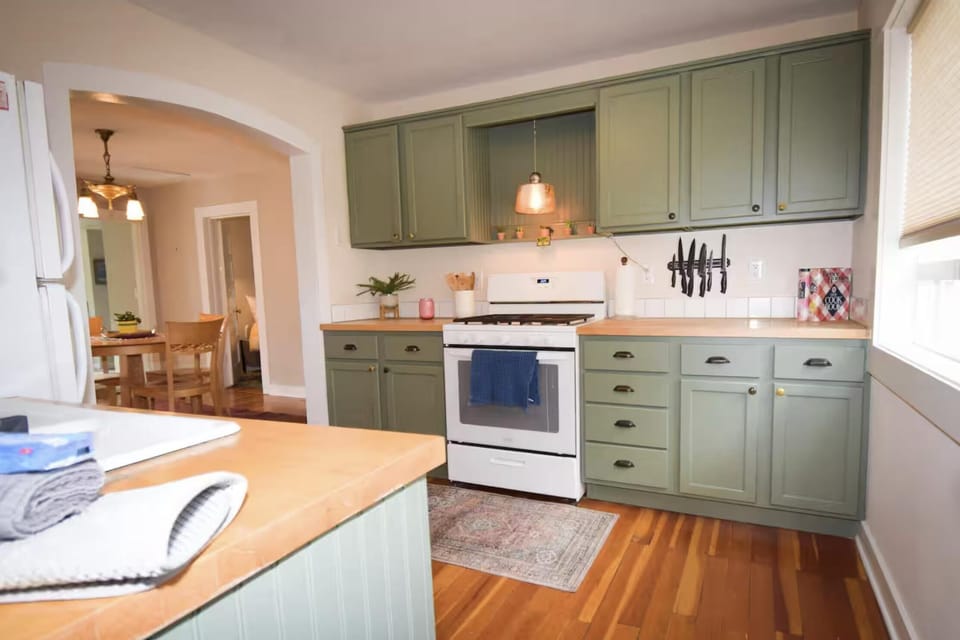 Charming kitchen with vintage green cabinets and hardwood floors