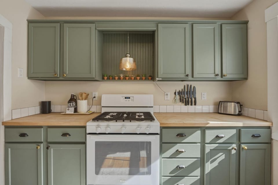 Charming vintage kitchen with green cabinets and hardwood floors