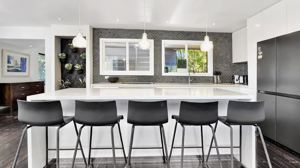 Open kitchen with bar seating and clean contemporary finishes.