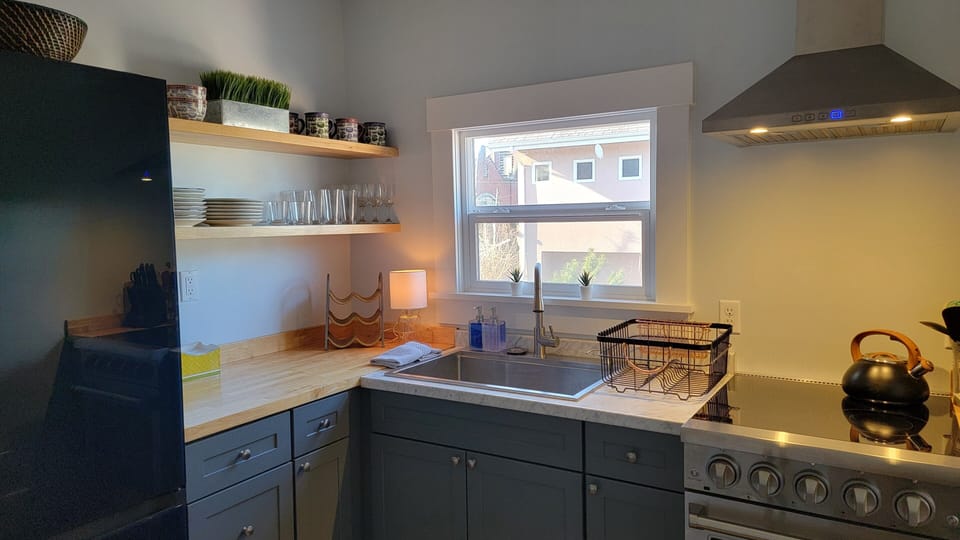 Modern kitchen with full size fridge/freezer, stove and oven, eating bar &stools