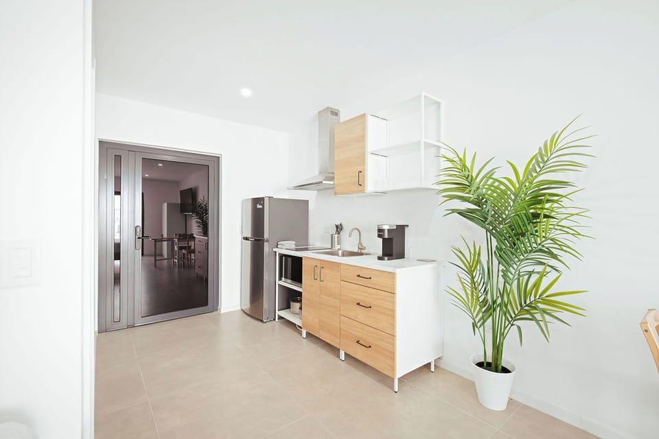 Sleek design meets perfect function. Welcome to your bright, modern escape featuring a fully-equipped kitchenette, stainless steel appliances, and a calming, minimalist aesthetic. Perfect for your stays where comfort is key.