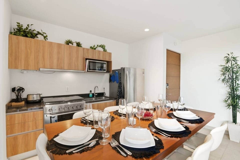 Fully equipped modern kitchen featuring stainless-steel appliances, a spacious stove and oven, microwave, full-size refrigerator, and all essential cookware and utensils—perfect for preparing meals during your stay.