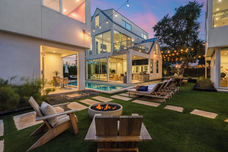 Golden-hour glow over a modern oasis with poolside lounges and cozy firepit seating.