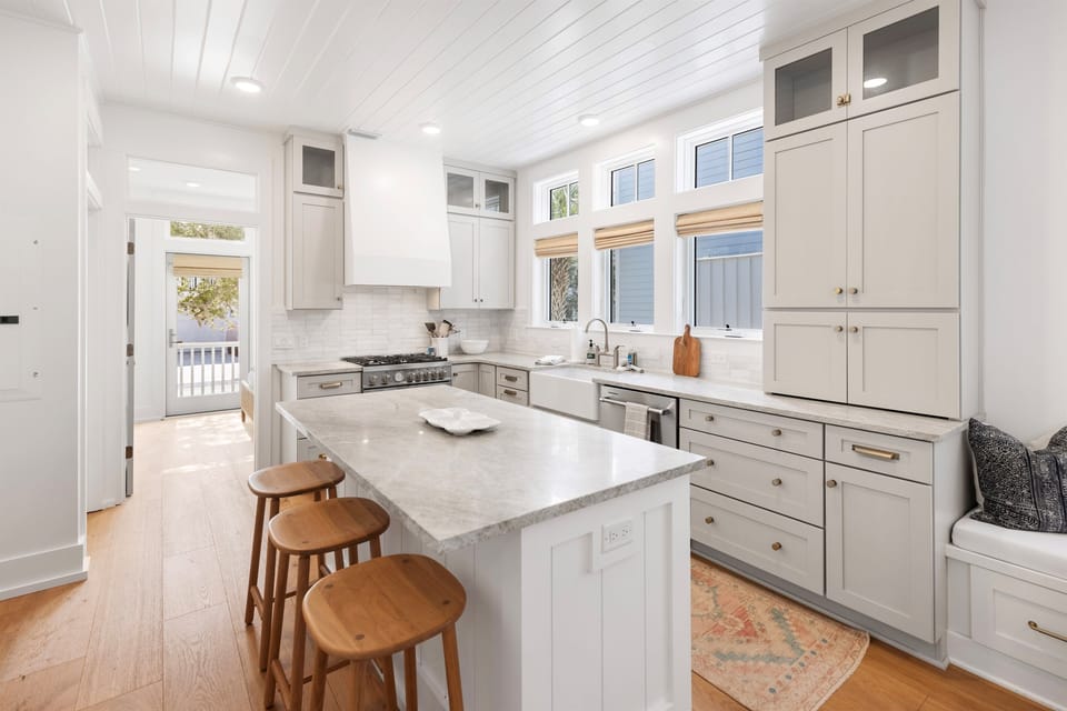 Your gourmet kitchen awaits with marble countertops, chef-grade appliances, and charming bar seating perfect for morning coffee or evening conversations.