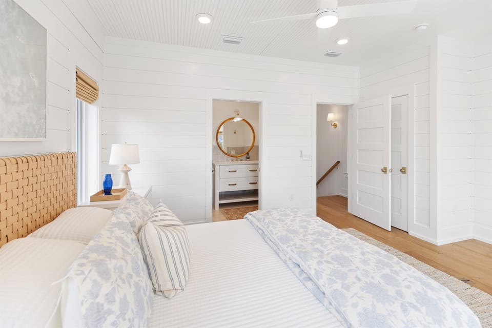 Drift into restful sleep in this bright, coastal-inspired bedroom featuring a plush bed and charming woven headboard that creates your perfect seaside retreat.