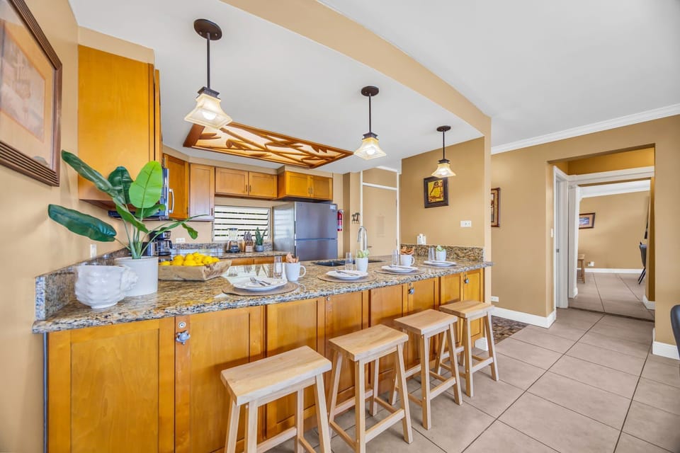 Kitchen view with granite counters, pendant lights, and warm décor accents.