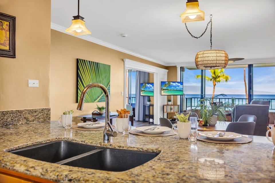 Kitchen counter with double sink, lemons, and open living space.