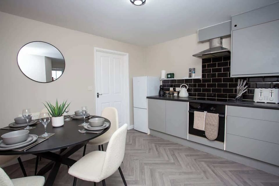 Modern kitchen and dining area with sleek finishes and space to enjoy meals together.