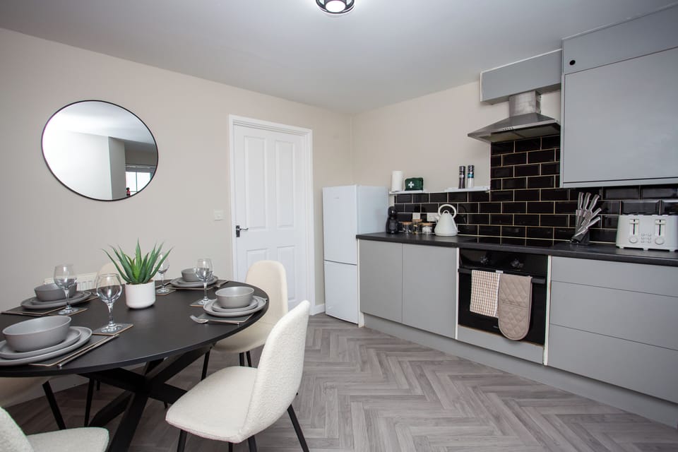 Modern kitchen and dining area with sleek finishes and space to enjoy meals together.
