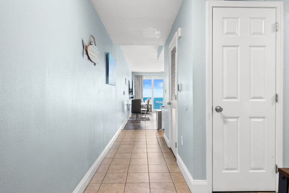 Welcoming entry hallway leading to bright coastal living spaces and breathtaking blue-water views ahead.