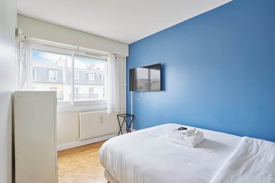 Chambre 2 avec meuble de rangement et TV
