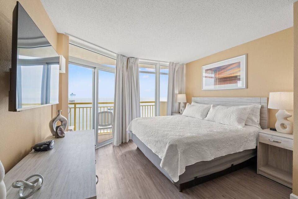 Wake up to crashing waves in this oceanfront main bedroom, with direct access to your private balcony.