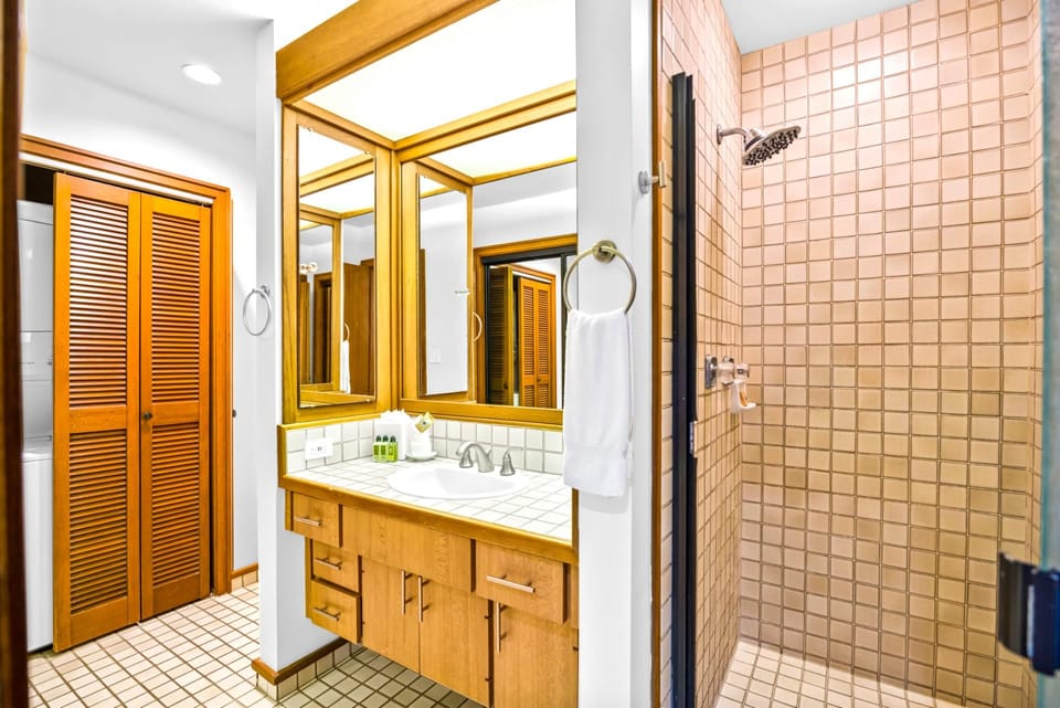 The primary bath features a walk-in shower and warm wood tones for a spa-like refresh.