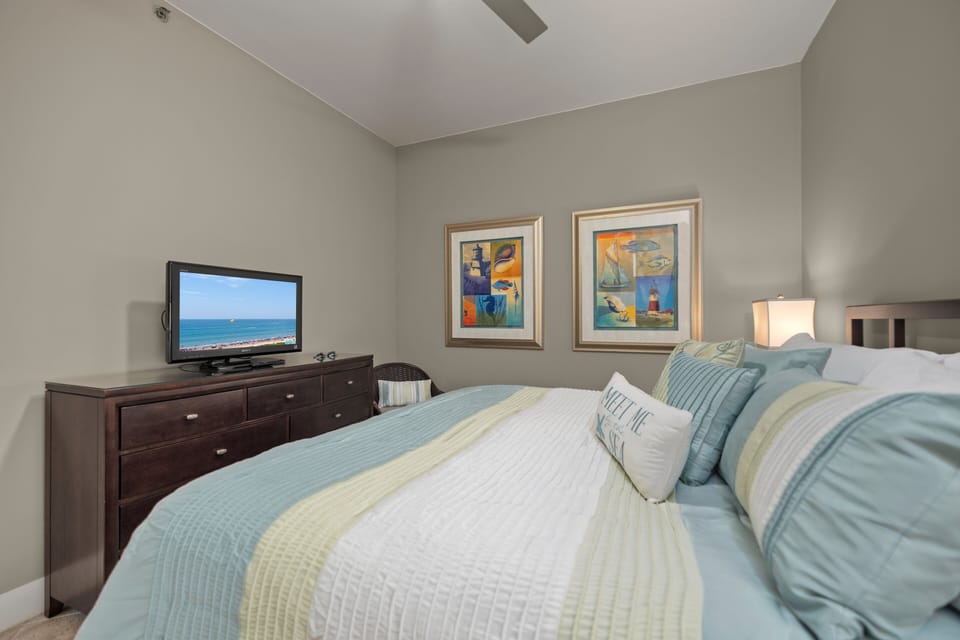 Comfortable guest bedroom featuring a king bed, TV, and coastal accents